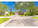 Two-story home featuring brick and vinyl siding, an attached garage, a long driveway, and mature trees at 5989 Ashmore Ln, Carmel, IN 46033