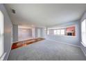 Spacious living room features soft gray walls, plush carpeting, a red accent wall, and hardwood flooring at 5989 Ashmore Ln, Carmel, IN 46033