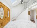 Bright foyer features stone flooring, an elegant staircase, and a skylight at 6413 N Wheeling Ave, Muncie, IN 47304