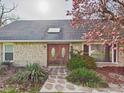 Stunning stone facade with beautiful wood double doors and a well-manicured front garden at 6413 N Wheeling Ave, Muncie, IN 47304