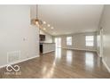 Spacious living room with an open concept, modern lighting, and wood-look flooring at 7951 Busby Bend Dr, Noblesville, IN 46062
