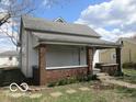 Classic house exterior with a covered porch featuring brick pillars and a welcoming entrance at 909 S Colfax St, Martinsville, IN 46151