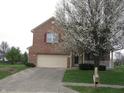 Two-story brick home with an attached two-car garage and flowering tree in front at 10762 Galant Fox Ct, Indianapolis, IN 46234