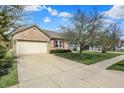 Inviting brick home with a two-car garage and a spacious driveway, great curb appeal at 12404 Rose Haven Dr, Indianapolis, IN 46235