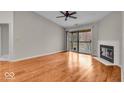 Open living space with wood floors, fireplace, and sliding door to outdoor deck at 12570 Timber Creek Dr # 7, Carmel, IN 46032