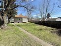 Expansive backyard featuring mature trees, green grass, and a partial view of the home at 1302 Lindley Ave, Indianapolis, IN 46241
