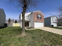 View of the home's front, showing the attached garage and lawn at 1404 Alonzo Pl, Indianapolis, IN 46217