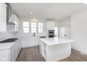 Modern kitchen with stainless steel appliances, center island, and bright white cabinets at 14532 Hanford Ln, Carmel, IN 46074