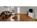 Spacious living room featuring laminate flooring, a comfortable couch, and ample natural light at 16838 Aulton Dr, Noblesville, IN 46060