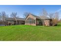 Expansive backyard featuring a sunroom, well-kept lawn, and a covered outdoor seating area for entertaining at 1791 S Conservation Club Rd, Morgantown, IN 46160
