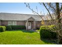 Well-maintained brick home with a manicured lawn, flowering trees and bushes under a clear blue sky at 1791 S Conservation Club Rd, Morgantown, IN 46160