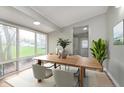 Light-filled dining room with a wooden table, minimalist chairs, and a large window offering views of the backyard at 1946 N Riley Ave, Indianapolis, IN 46218