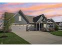 Charming single-Gathering home featuring a three-car garage, covered porch and well-manicured lawn at dusk at 1972 Mobley Dr, Westfield, IN 46074