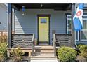 Inviting front porch with seating and a pop of color from the yellow door sets a welcoming tone at 2043 Winthrop Ave, Indianapolis, IN 46202