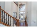 Bright and airy two-story foyer featuring hardwood floors, a statement chandelier, and decorative glass front door at 219 Surrey Hill, Noblesville, IN 46062