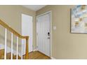 Bright entryway featuring neutral walls, white door, and wooden banister at 2210 Douglas Rd, Indianapolis, IN 46220