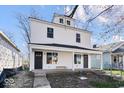 Charming two-story home featuring a covered front porch with white accents and black doors at 241 N Tacoma Ave, Indianapolis, IN 46201