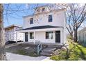 Charming two-story home featuring a covered front porch with white accents and black doors at 241 N Tacoma Ave, Indianapolis, IN 46201