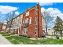 Beautiful townhome with a brick facade, balcony, and well-manicured lawn at 253 1St Nw St, Carmel, IN 46032