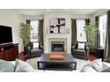 Cozy living room featuring a marble fireplace, modern artwork, and hardwood flooring at 253 1St Nw St, Carmel, IN 46032