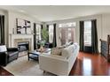 Elegant living room with fireplace, hardwood floors, and French doors to the balcony at 253 1St Nw St, Carmel, IN 46032