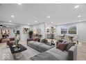 Bright, staged living room with modern furniture, neutral walls, luxury vinyl plank floors, and seamless flow into dining area at 322 S Boehning St, Indianapolis, IN 46219