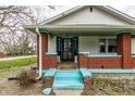 Inviting front porch features brick columns, vibrant blue accents, and an eye-catching security door at 359 N Whitcomb Ave, Indianapolis, IN 46224