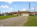 Well-maintained single-story home featuring stone accents, an attached garage, and a gravel driveway at 3638 Redfern Dr, Indianapolis, IN 46237