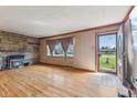 Inviting living room featuring hardwood floors, a stone fireplace, and a view of the outdoors at 3638 Redfern Dr, Indianapolis, IN 46237
