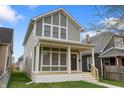 An elegant two-story home featuring gray siding, white trim, and a inviting front porch at 401 Iowa St, Indianapolis, IN 46225