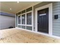 Inviting covered porch showcasing a stylish front door, neutral trim, and wood flooring at 401 Iowa St, Indianapolis, IN 46225