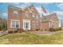 Inviting brick home featuring an elegant front entrance, mature landscaping, and a manicured lawn at 6272 Turnbridge Dr, Avon, IN 46123