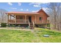Charming log cabin with a red roof and inviting covered porch at 6351 Dixon Rd, Columbus, IN 47201