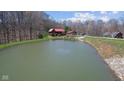 Scenic view of a tranquil pond and log cabin nestled in the trees at 6351 Dixon Rd, Columbus, IN 47201