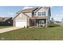 Daytime view of a two-story home featuring brick accents and a well-maintained front yard at 6476 W Mulberry Way, Greenfield, IN 46140