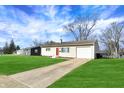 Inviting single-story home with a well-manicured lawn and driveway leading to an attached garage at 676 Nelson Dr, Mooresville, IN 46158