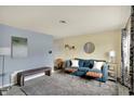 Bright living room with a comfy blue sofa, plush rug, and neutral walls at 676 Nelson Dr, Mooresville, IN 46158
