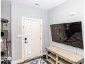 Bright entryway featuring a white door with glass panels, a mounted TV, and a wooden bench at 694 N Sobota Way, Trafalgar, IN 46181