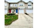 Exterior view of townhomes with colorful front doors and well-maintained lawns on a sunny day at 8030 Windham Lake Way, Indianapolis, IN 46214