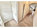 Inviting hallway with wood floors, a staircase, and white doors for storage and access at 8030 Windham Lake Way, Indianapolis, IN 46214
