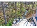 Relaxing backyard deck with comfortable lounge chairs and scenic view of the lush trees and a stream at 8990 Pickwick Dr, Indianapolis, IN 46260