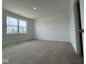 Bright bedroom featuring neutral carpet, a large window, and fresh paint, perfect for relaxation at 915 Saddlebrook Farms Blvd, Whiteland, IN 46184