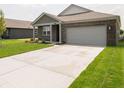 Charming brick house featuring a two car garage, landscaping, and a concrete driveway at 915 Saddlebrook Farms Blvd, Whiteland, IN 46184
