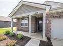 Exterior shot of a charming single-Gathering home with brick facade, landscaping and inviting entryway at 915 Saddlebrook Farms Blvd, Whiteland, IN 46184