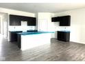 Modern kitchen featuring dark cabinets, a large center island, and wood flooring at 915 Saddlebrook Farms Blvd, Whiteland, IN 46184