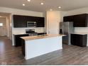 Modern kitchen with stainless steel appliances, quartz countertops, and a large island with eat-in counter at 915 Saddlebrook Farms Blvd, Whiteland, IN 46184