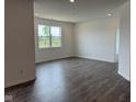 Open concept living room featuring recessed lighting, LVP floors, and a large window with beautiful backyard views at 915 Saddlebrook Farms Blvd, Whiteland, IN 46184