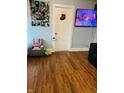 Cozy living room featuring wood floors, a recliner chair, and television at 918 N Olney St, Indianapolis, IN 46201