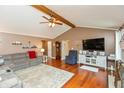 Inviting living room featuring vaulted ceilings, hardwood floors, a comfortable sofa, and a TV at 1002 Corey Ln, Plainfield, IN 46168