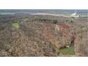 Aerial view of wooded property with a home, pond, and defined property lines in a rural setting at 1037 E Woodall Ct, Martinsville, IN 46151